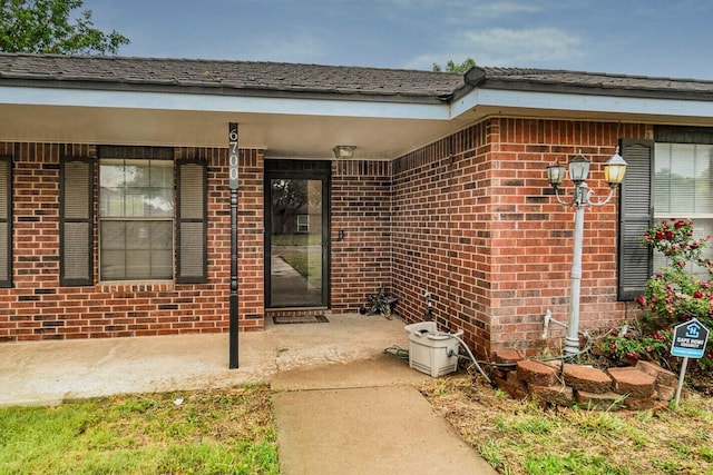 6700 Deer Park Dr, Amarillo, TX 79124 - view of exterior entry featuring brick siding and a patio area