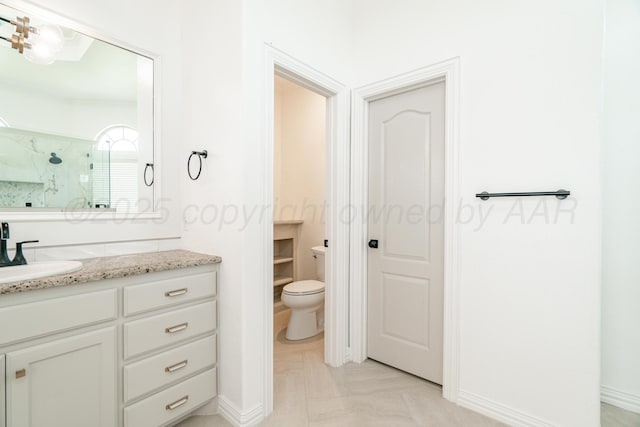 full bath with baseboards, toilet, vanity, and a walk in shower