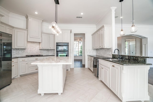 kitchen featuring stainless steel appliances, a sink, visible vents, crown molding, and a breakfast bar