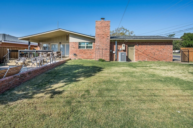back of property with a patio area and a lawn