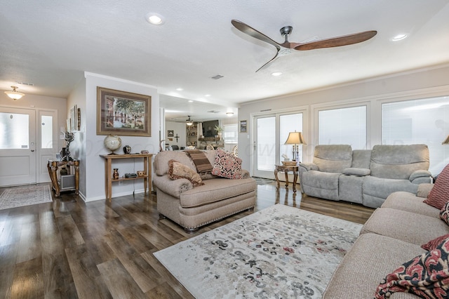 living room with dark wood-type flooring, a textured ceiling, and ceiling fan