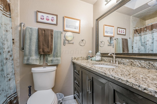 bathroom featuring curtained shower, vanity, and toilet