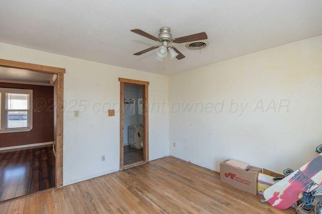 unfurnished bedroom featuring wood-type flooring, visible vents, and a ceiling fan