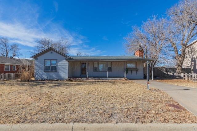 ranch-style house with a chimney and fence