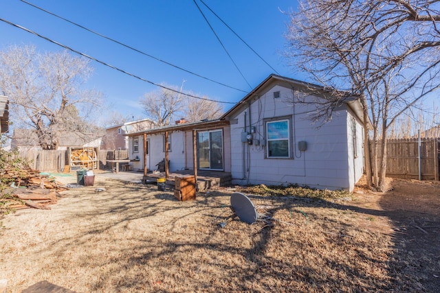 rear view of house with a patio area and fence