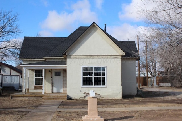 view of front of property featuring a shingled roof, a porch, and stucco siding