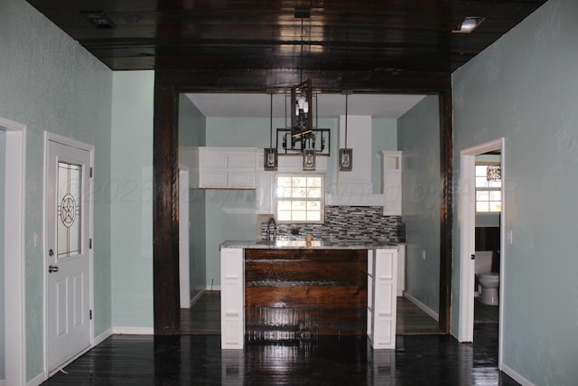 kitchen featuring dark wood-type flooring, plenty of natural light, white cabinets, and decorative backsplash