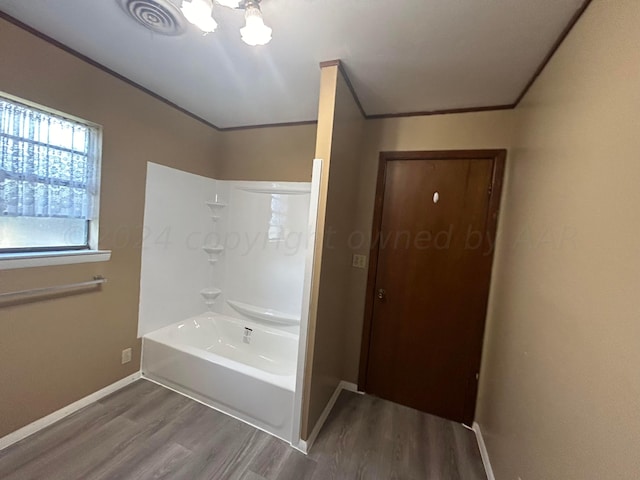 bathroom featuring hardwood / wood-style floors, crown molding, and shower / bathing tub combination