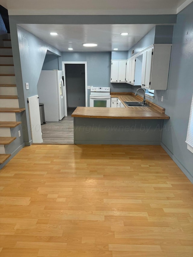 kitchen featuring kitchen peninsula, sink, white cabinetry, light wood-type flooring, and white appliances