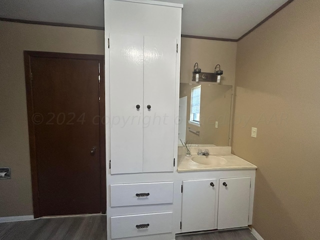 bathroom with hardwood / wood-style flooring, vanity, and ornamental molding