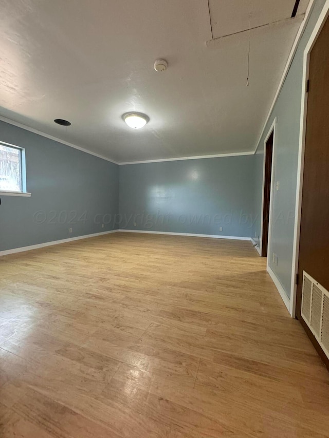 unfurnished room featuring ornamental molding and light hardwood / wood-style flooring