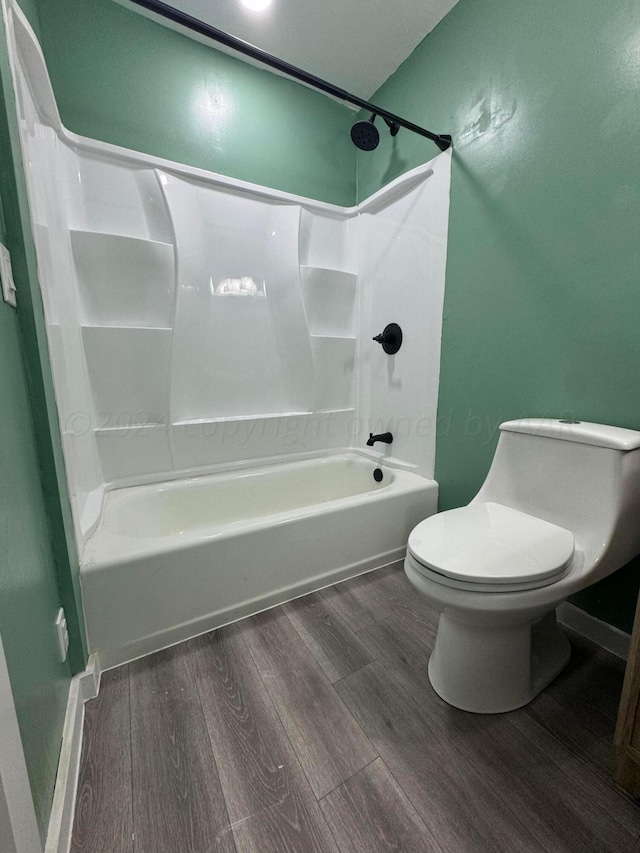 bathroom with toilet, wood-type flooring, and shower / washtub combination