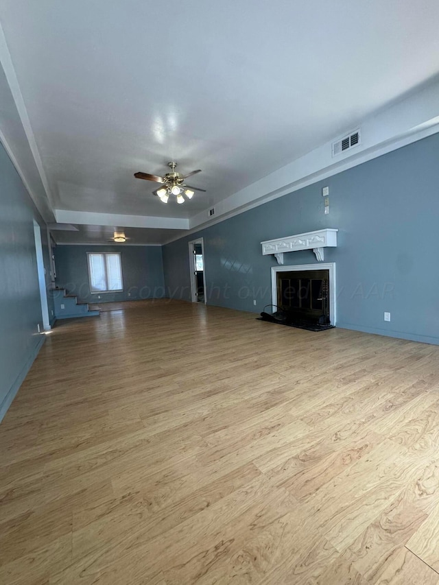 unfurnished living room featuring light wood-type flooring and ceiling fan