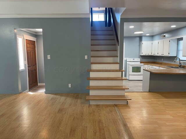 stairway featuring hardwood / wood-style floors, plenty of natural light, and sink