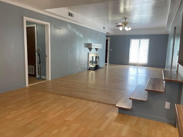 unfurnished living room featuring ceiling fan and light wood-type flooring