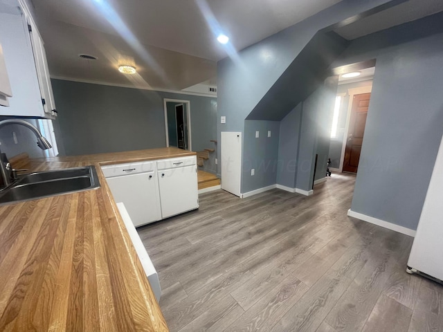 kitchen with white cabinetry, sink, and light wood-type flooring