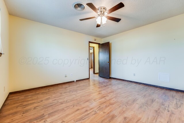 unfurnished room with visible vents, a textured ceiling, light wood-type flooring, and a ceiling fan