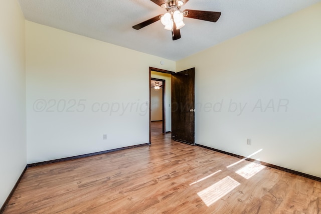 spare room with light wood-style flooring, baseboards, and a ceiling fan