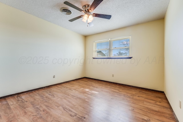 empty room with light wood-style floors, visible vents, a textured ceiling, and ceiling fan
