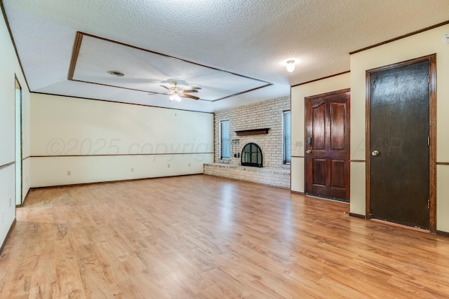 unfurnished living room featuring light wood-type flooring, ceiling fan, a fireplace, and a textured ceiling