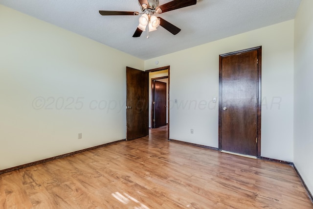 unfurnished bedroom with a closet, baseboards, a ceiling fan, light wood-style floors, and a textured ceiling