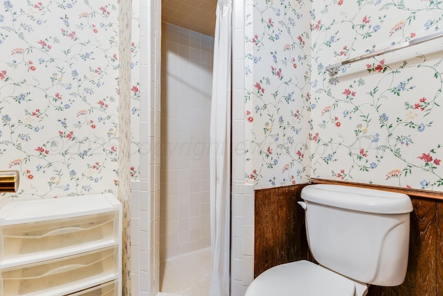 bathroom with a shower stall, wallpapered walls, and toilet