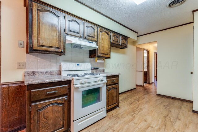 kitchen featuring visible vents, a textured ceiling, under cabinet range hood, white range with gas cooktop, and light wood-style flooring