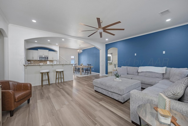 6809 Fanchun St, Amarillo, TX 79119 - living room featuring arched walkways, ceiling fan, crown molding, light wood-style flooring, and recessed lighting