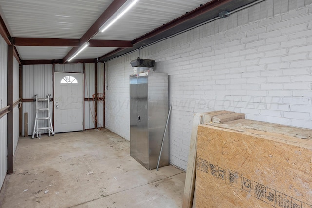 6809 Fanchun St, Amarillo, TX 79119 - miscellaneous room with unfinished concrete floors and brick wall