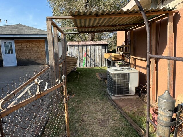 view of yard with central AC unit and a storage shed