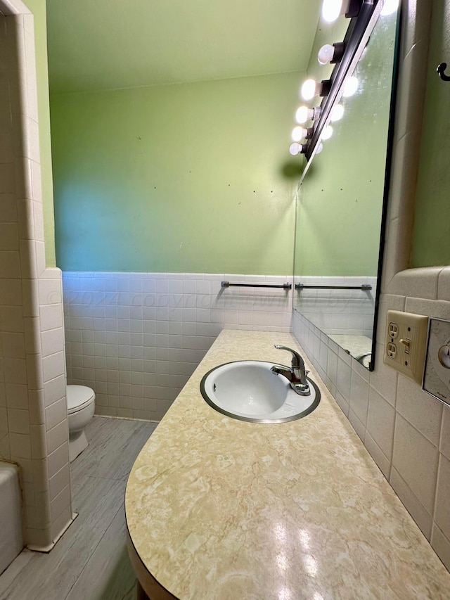 bathroom featuring tile walls, vanity, and toilet