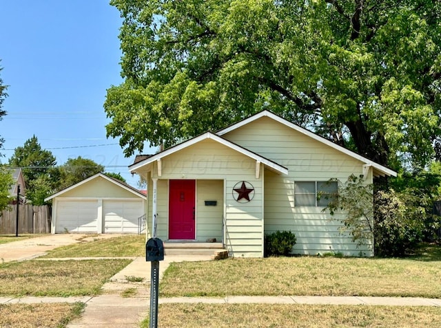 view of front of house with a garage, a front yard, and an outdoor structure