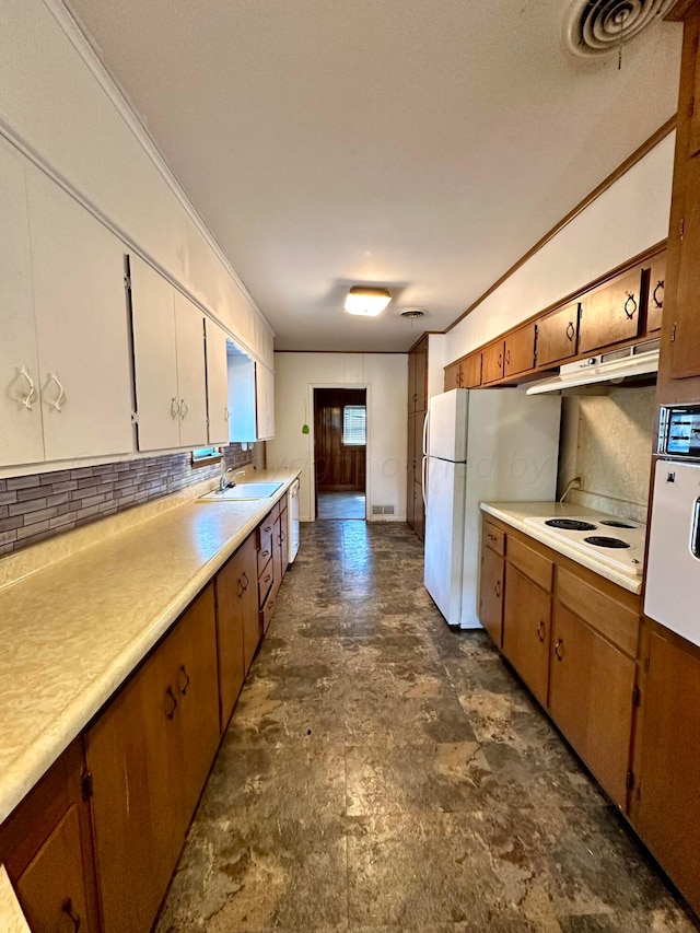 kitchen featuring backsplash, white refrigerator, sink, and ornamental molding