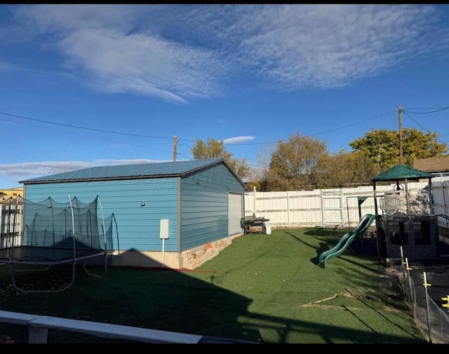 view of yard with a trampoline and a playground