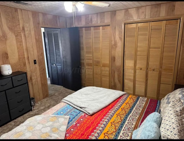 100 Bunavista St, Borger, TX 79007 - carpeted bedroom with two closets, wooden walls, and ceiling fan