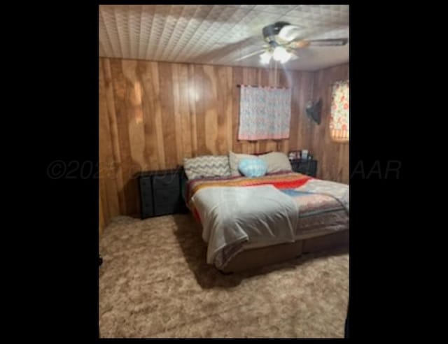 100 Bunavista St, Borger, TX 79007 - carpeted bedroom featuring ceiling fan and wood walls