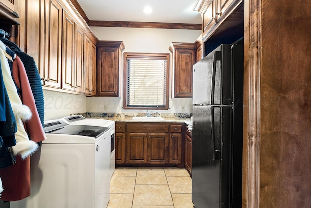 clothes washing area with ornamental molding, separate washer and dryer, sink, and light tile patterned floors