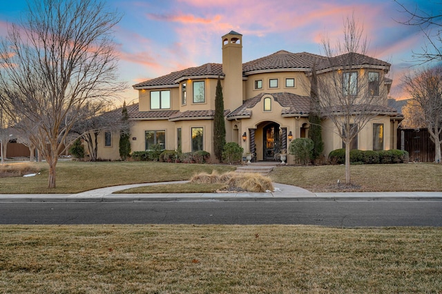 mediterranean / spanish home with a lawn