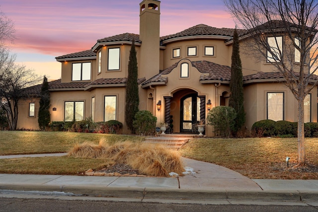 mediterranean / spanish home with a lawn