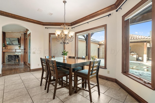 tiled dining area featuring crown molding and a fireplace