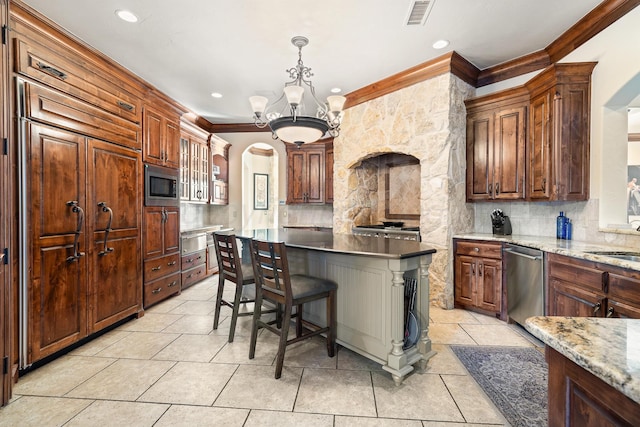 kitchen with tasteful backsplash, an inviting chandelier, crown molding, built in appliances, and decorative light fixtures