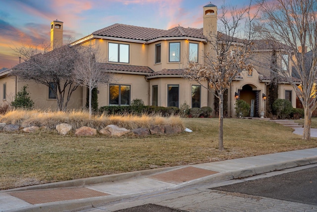 mediterranean / spanish-style house with a lawn