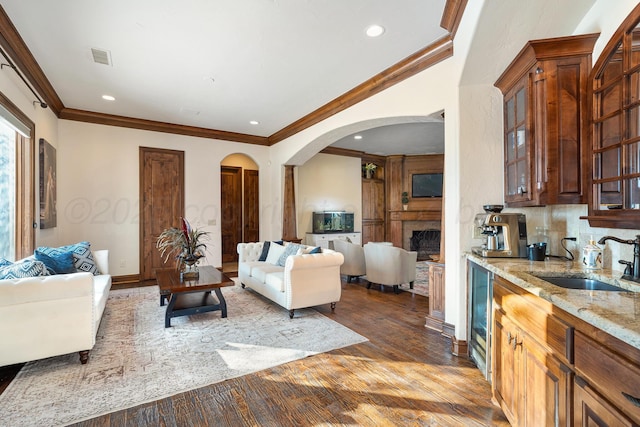 living room with crown molding, sink, and hardwood / wood-style floors