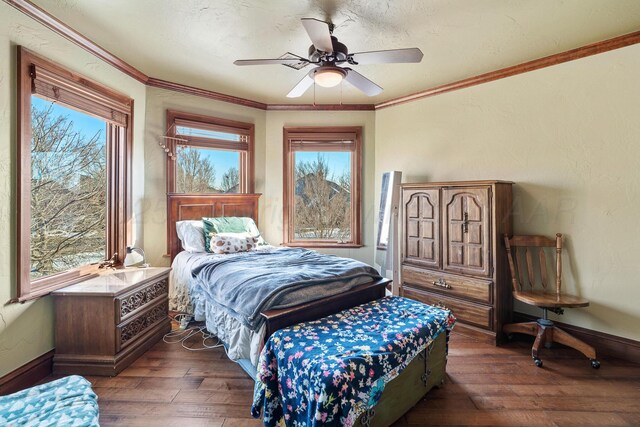 bedroom featuring multiple windows, ornamental molding, dark hardwood / wood-style floors, and ceiling fan