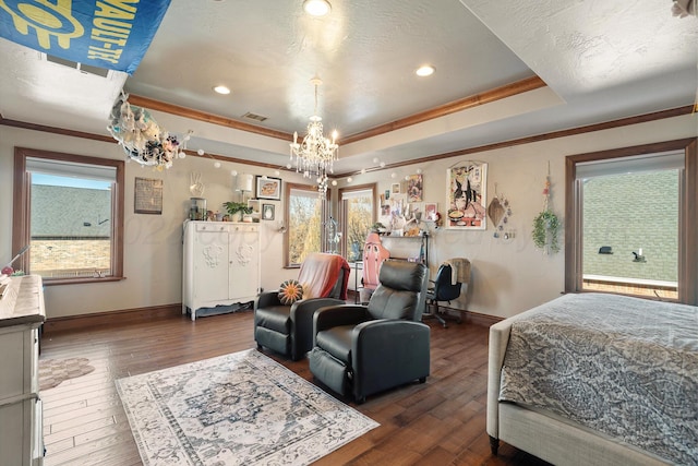 bedroom featuring crown molding, dark wood-type flooring, an inviting chandelier, and a tray ceiling