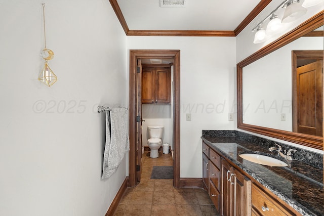 bathroom featuring crown molding, vanity, and toilet