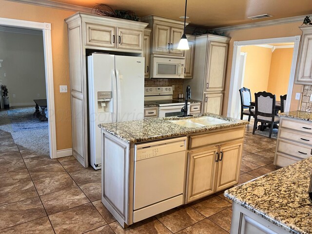 kitchen with pendant lighting, white appliances, cream cabinets, sink, and tasteful backsplash