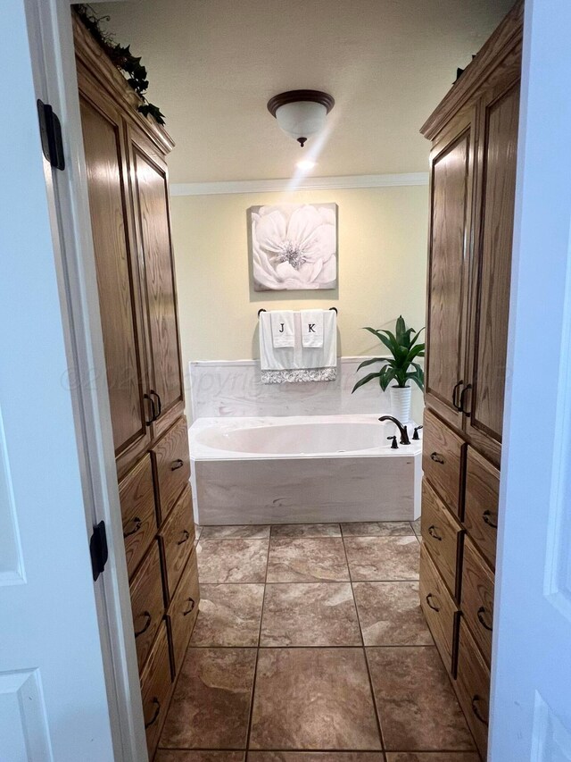 bathroom featuring tile patterned flooring, a bathtub, and crown molding