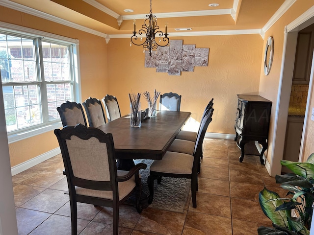 dining area with a tray ceiling, crown molding, tile patterned flooring, and an inviting chandelier