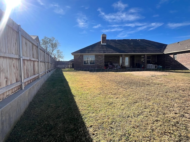 rear view of property featuring a lawn